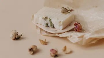 Seifenstück mit getrockneten Blumen auf Papier.
