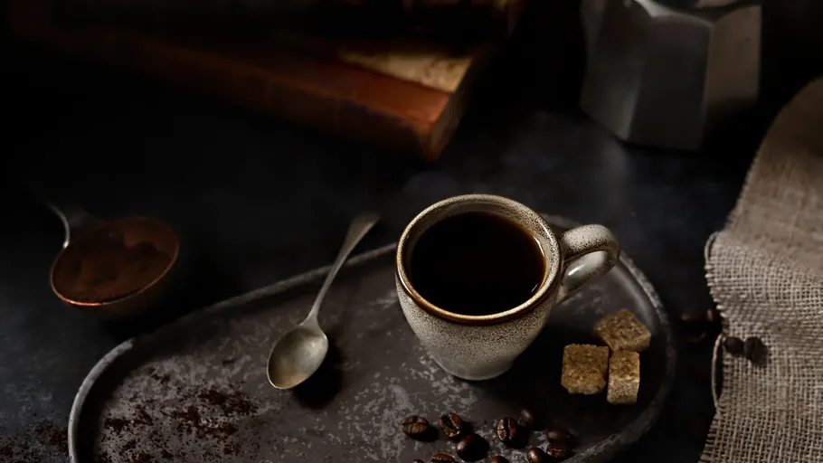 Coffee cup on tray with sugar cubes.