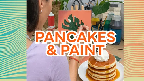 Woman painting leaf with pancakes nearby.