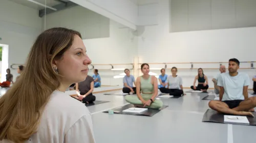 People sitting in yoga studio, meditating.