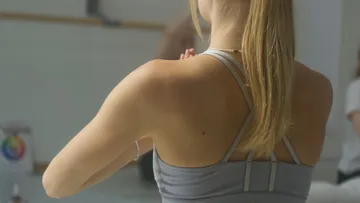 Woman practicing yoga indoors, back view.