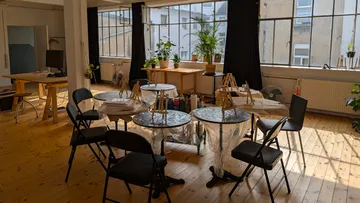 Art studio with empty chairs and tables.