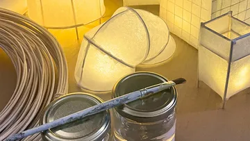 Brush resting on jar surrounded by lights.