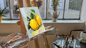 Gemälde von Zitronen auf Staffelei drinnen.