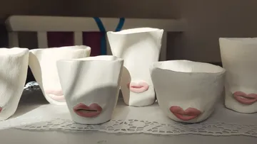 Keramiktassen mit Lippen, Sonnenlicht Hintergrund.
