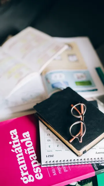 Books and glasses on a cluttered table.