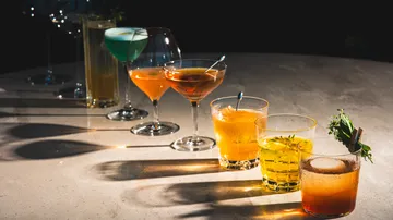 Verschiedene Cocktails auf einem Tisch angeordnet.