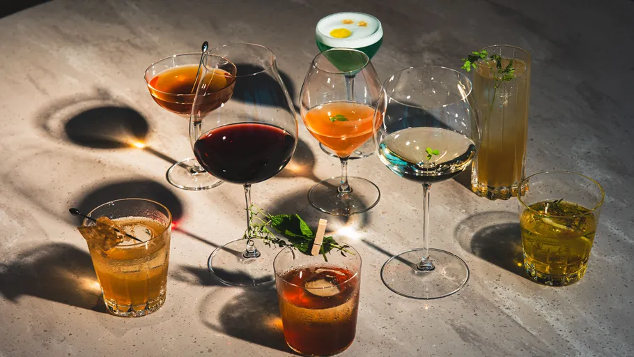 Acht verschiedene Cocktails auf einem Tisch.