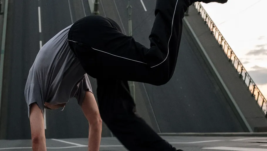 Person doing a handstand on a bridge.
