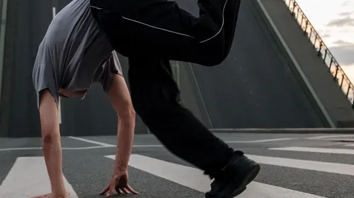 Person breakdancet auf städtischer Straße.