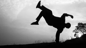 Silhouette eines Tänzers im Handstand im Freien.
