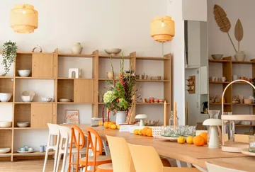 Dining room with modern decor, wooden shelves.