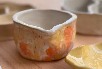 Bunte Keramikschale auf Holzoberfläche.
