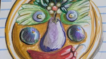 Face formed by fruits and vegetables on plate