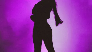 Silhouette of person standing, purple background.