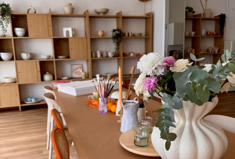 Flowers in vase on art studio table.