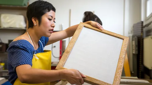 Frau stellt Papier in Werkstatt her.