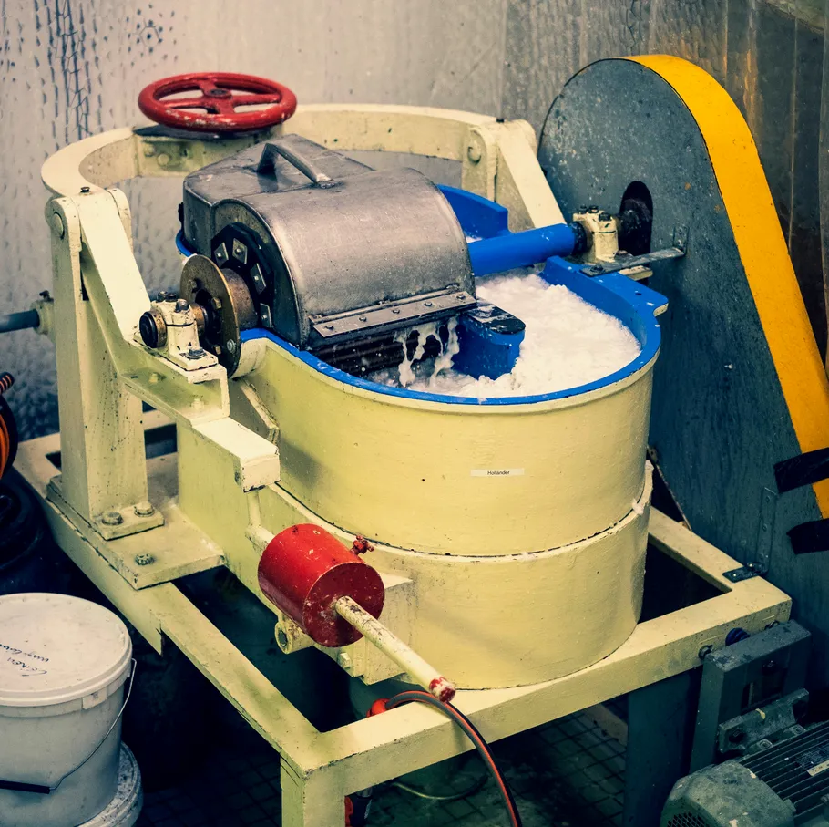 Industrial mixer processing material indoors.