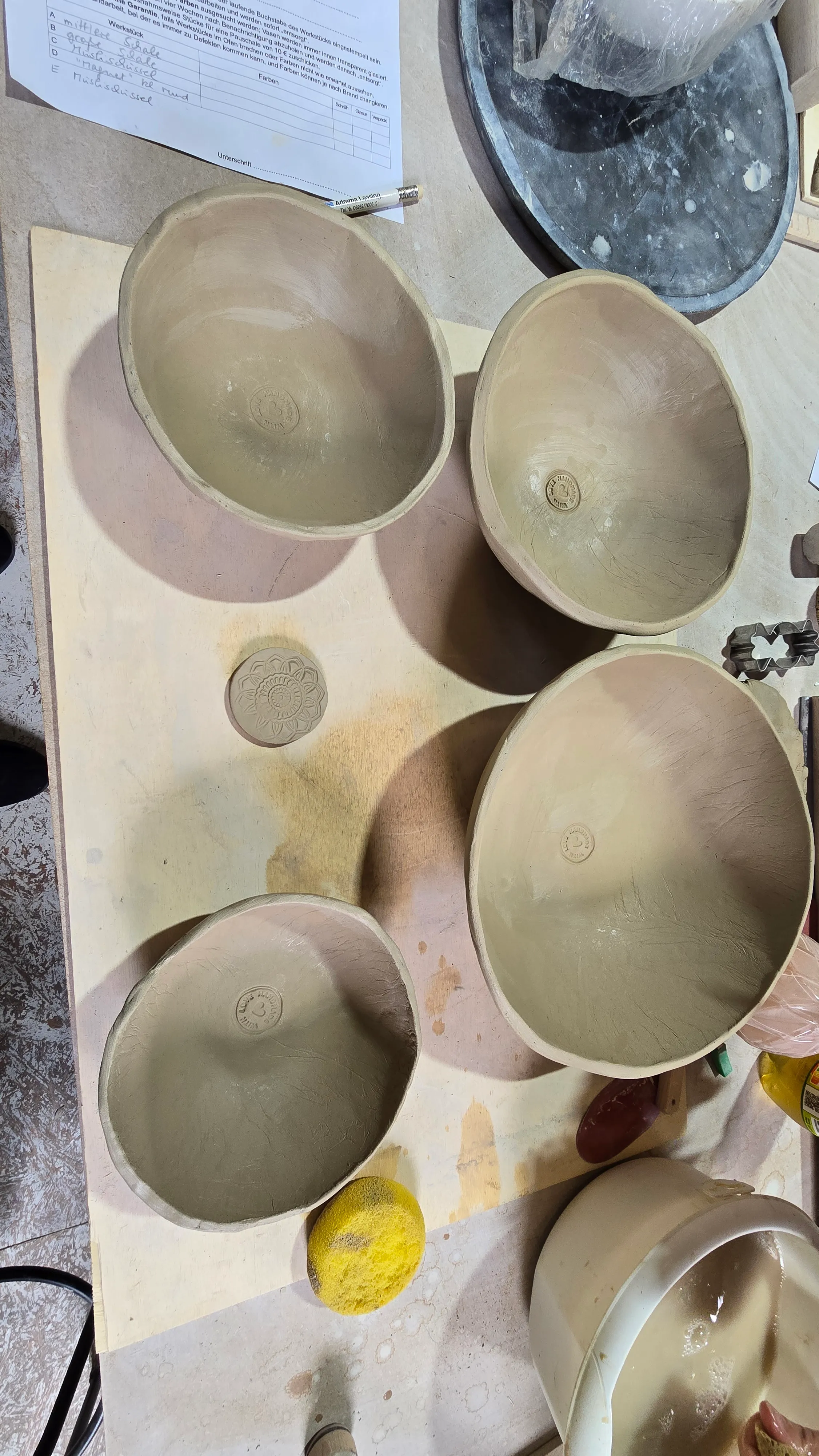 Clay bowls drying on workshop table.