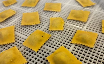Ravioli liegen auf einem Trockenregal.