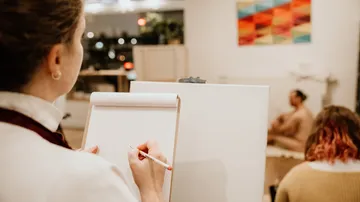 Künstler zeichnet sitzendes Modell im Studio.