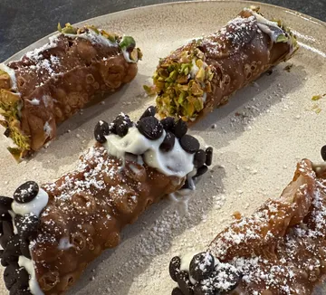 Cannoli with toppings on a plate.