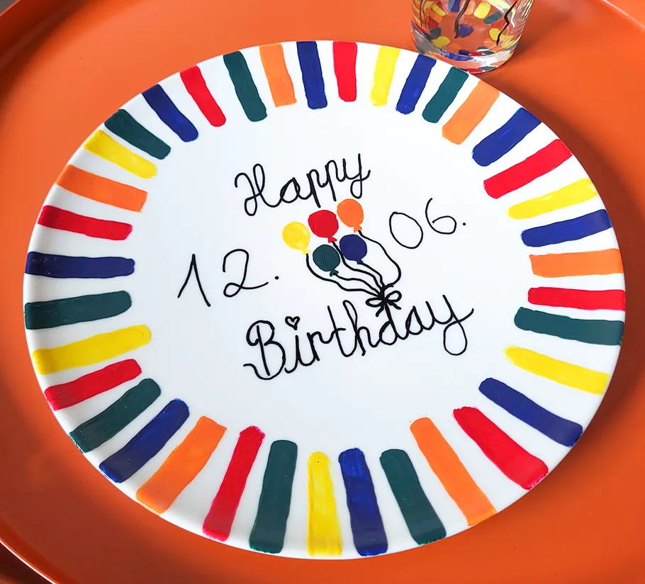 Colorful birthday plate with text and balloons.