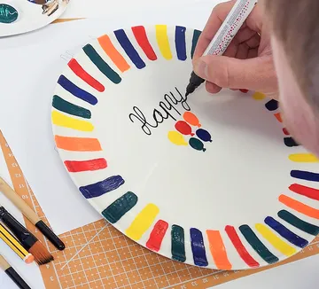 Hand bemalt bunten Teller mit "Happy"-Text.