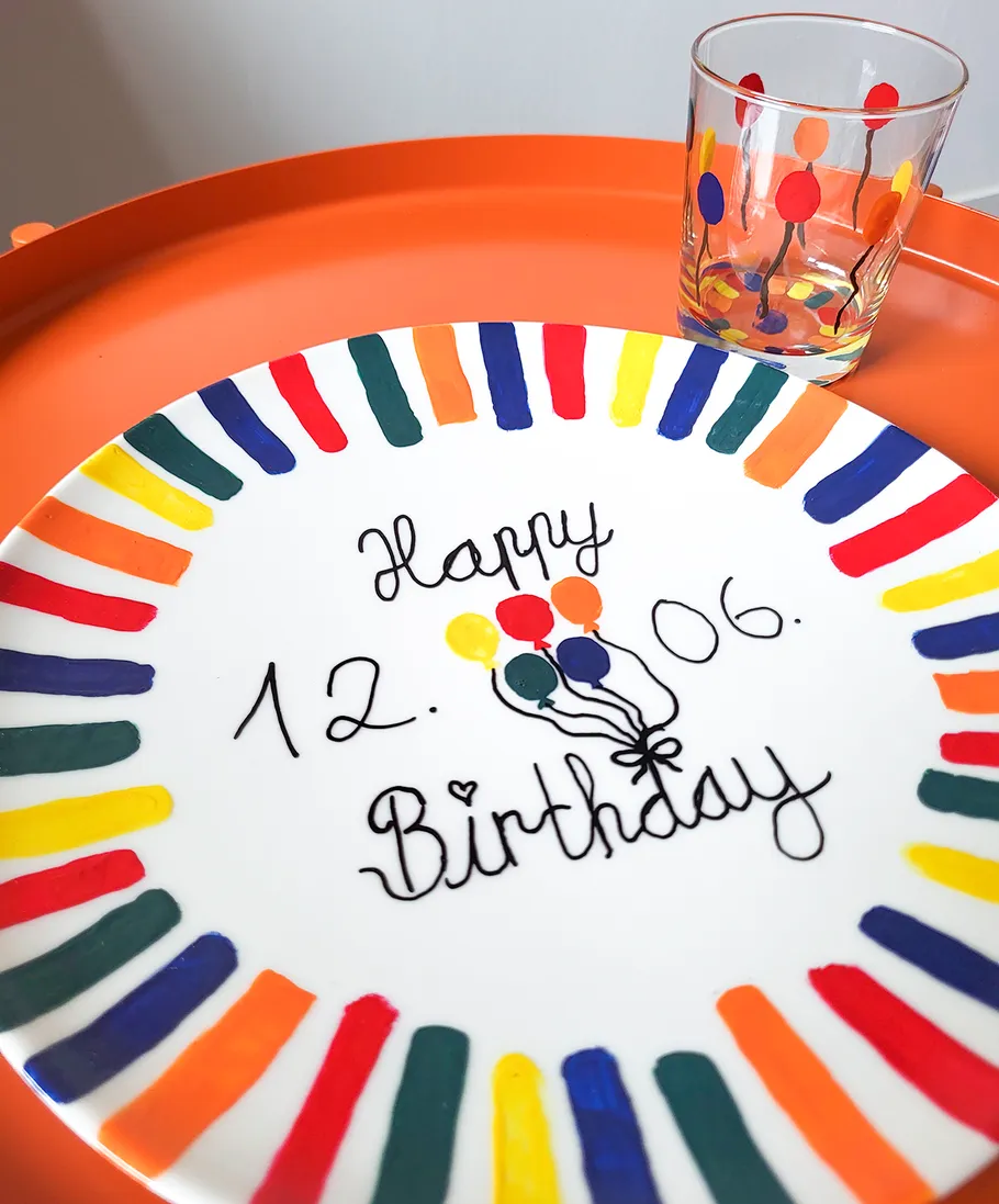 Colorful plate and glass on orange tray.