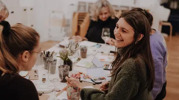 Women talking at an arts and crafts table.
