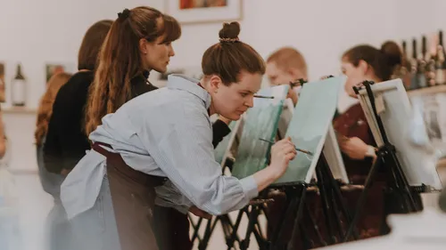 People painting on canvases in a studio.