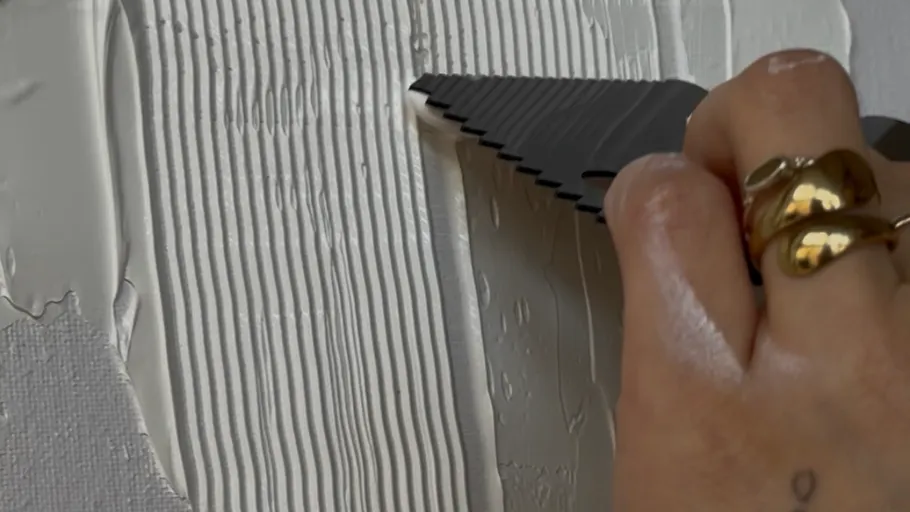 Hand applying plaster with notched trowel.