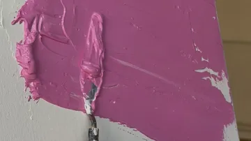 Farbe mit Malmesser auf Leinwand verteilt.