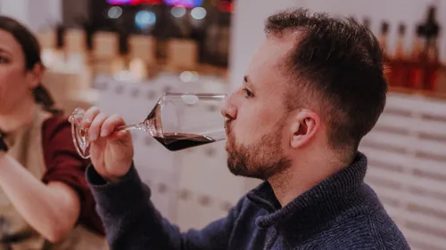 Mann probiert Wein in einer Bar.