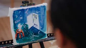 Painting of room with chair, viewed closely.