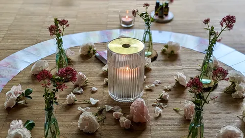 Kerzen und Blumen im Kreis angeordnet.