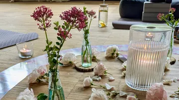 Kerzen und Blumen auf Holzboden arrangiert.