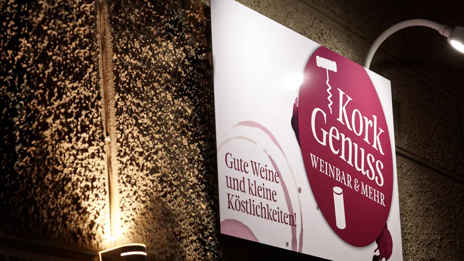 Schild mit Text an strukturierter Wand draußen.