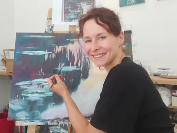 Artist painting on canvas in studio.