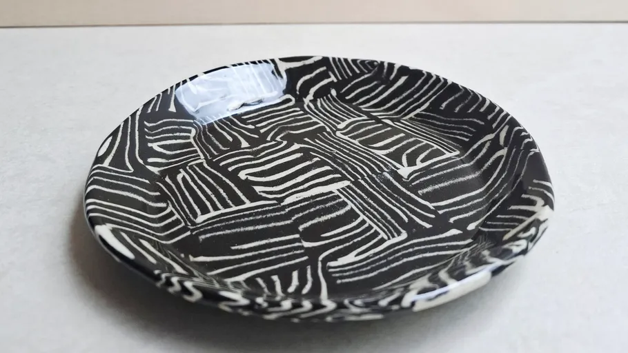 Ceramic plate with abstract black pattern.