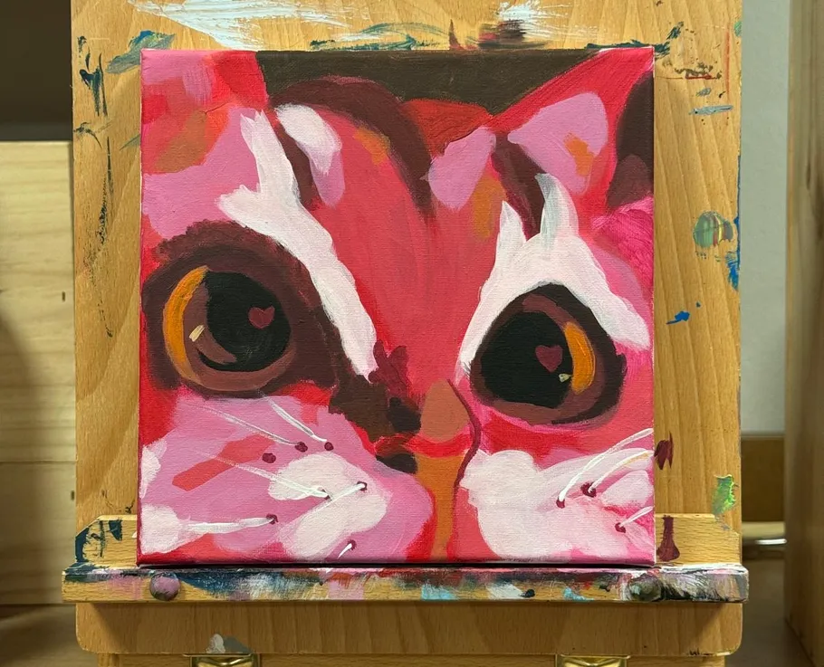 Colorful cat painting on wooden easel.