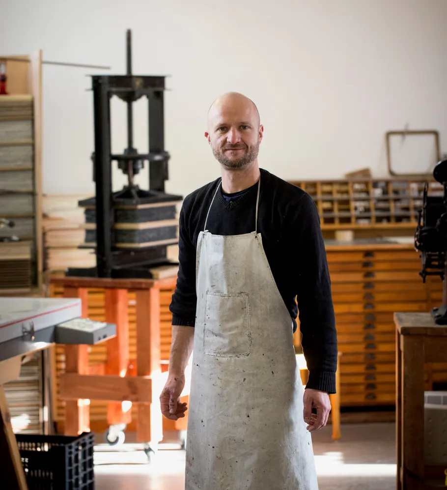 Man in apron standing in workshop.