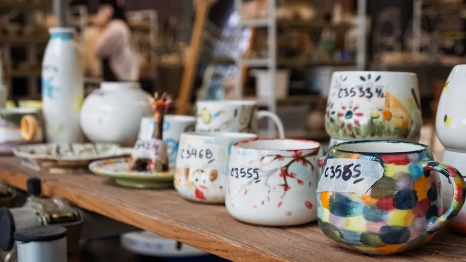 Colorful mugs displayed on wooden table.