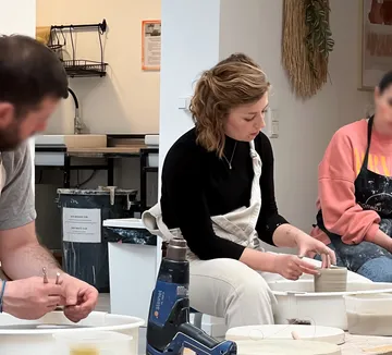 People sculpting clay in a studio.