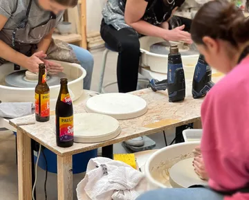 People making pottery in a workshop.