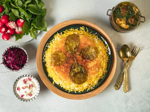 Bunt dekorierter Reis mit Gemüse auf einem Holzteller.