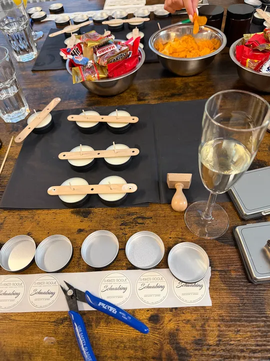 Candles, snacks, and tools on wooden table.