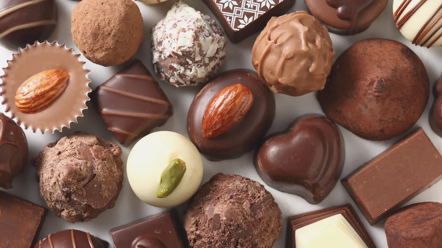 Assorted chocolates arranged on flat surface.