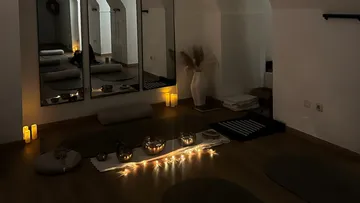 Meditative room with candles and cushions.
