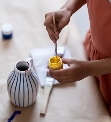 Hände rühren Farbe mit Pinsel, Tischdekoration.